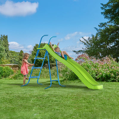 Two children enjoy the outdoors with the TP Toys 8ft (2.2m) Ripple Wavy Slide & Stepset—one climbing up while the other slides down, having fun in a grassy garden.