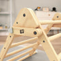 Close-up of the TP Toys TP Active-Tots Pikler Style Wooden Climbing Triangle & Slide, made from FSC® certified wood with rounded edges and a light finish, set in a softly lit indoor environment.