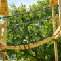 The TP Toys TP Skywood Wooden Clatter Bridge - FSC® certified features metal railings and connects two elevated platforms outdoors, making it ideal for modular climbing frames and crafted from responsibly sourced wood.