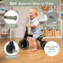 A toddler enjoys the Zoomee Balance Bike to Trike from TP Toys in black and green, featuring soft grip handles, an adjustable seat, indoor/outdoor versatility, and balance bike mode that supports child development.