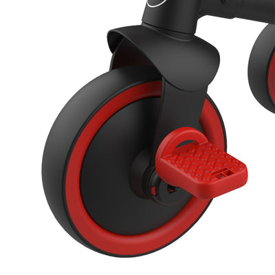 Close-up of the black and red wheel on the TP Toys Zoomee 2 in 1 Trike – Firecracker, showcasing its textured red foot pedal connected to the axle.