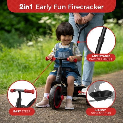 A young child rides the TP Toys Zoomee 2 in 1 Trike – Firecracker, a black and red adjustable tricycle with easy steer handlebars and storage tub, enjoying early fun along a park path.