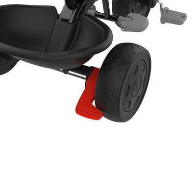 Close-up of the Zoomee 4 in 1 Deluxe Trike - Grey Storm by TP Toys, showing its rear wheel with the red brake lever engaged and the plastic footrest visible in the background.