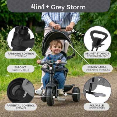 An adult pushes a child on the Zoomee 4 in 1 Deluxe Trike - Grey Storm by TP Toys, featuring parental steering, adjustable seat, safety belt, control pedals, storage compartment, removable handle, and foldable footrests.