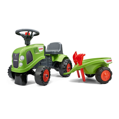 The TP Toys Falk Claas Baby Tractor is a green and black ride-on with a steering wheel, trailer, red rake, shovel, and authentic CLAAS branding on both the baby tractor and trailer.