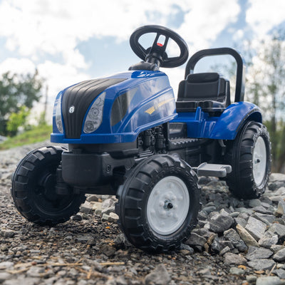 A Falk New Holland Tractor with Trailer and Opening Bonnet by TP Toys, featuring a blue body and black wheels, is parked outdoors on gravel under a partly cloudy sky.