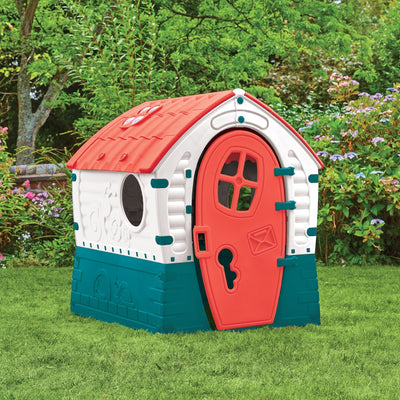 The TP Toys Palplay Plastic Dream Playhouse features a colorful, UV-resistant design with a red roof, white walls, and a red door, perfect for outdoor garden play among trees and flowers.
