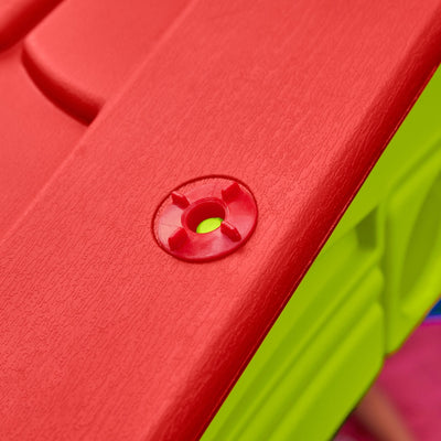 Close-up of the textured red plastic surface with a circular screw cover on the TP Toys Palplay Plastic Playhouse of Fun—ideal for sturdy indoor and outdoor playhouse adventures.