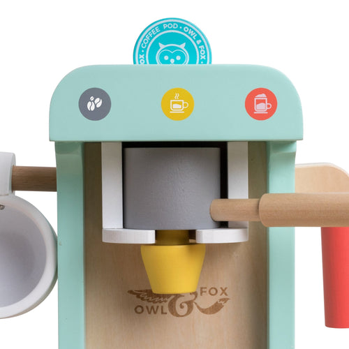 A close-up of the Owl & Fox Wooden Coffee Machine by TP Toys, FSC® certified, featuring a cup, wooden handles, and colorful buttons for pretend play. The Owl & Fox name and owl logo are visible, perfect for Montessori imaginative fun.