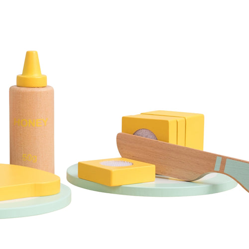 The TP Toys Owl & Fox Wooden Toaster Set (FSC® certified) is a Montessori pretend play set featuring a honey bottle, stacked wooden blocks, toy knife, and pastel green plates—perfect for imaginative kitchen fun.