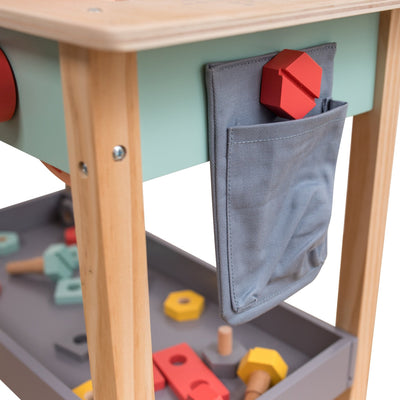 The TP Toys Owl & Fox Wooden Workbench Set - FSC® certified features a grey fabric pocket holding a red geometric block, with assorted toy bolts and blocks in the lower tray—ideal for pretend play and creative fun.