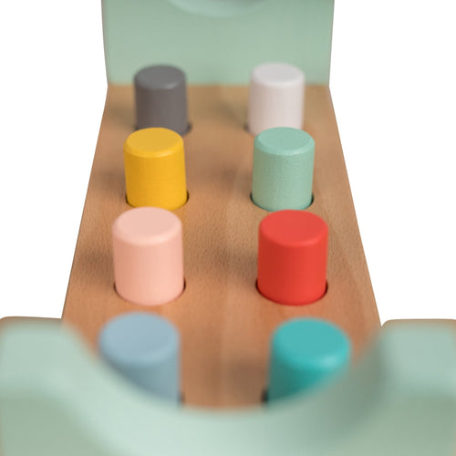 The Owl & Fox Wooden Hammer Bench by TP Toys features colorful cylindrical pegs on a natural wood base, helping develop hand-eye coordination. Made from FSC® certified wood in gray, yellow, pink, blue, white, red, and turquoise.