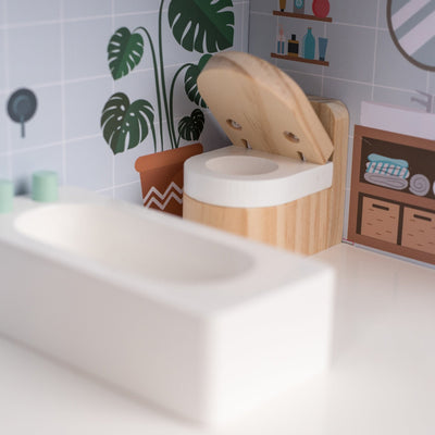 The Owl & Fox Wooden Dolls House by TP Toys includes a charming miniature bathroom with a wooden toilet, white bathtub, and illustrated plant wall tiles—perfect accessories for pretend play in any dolls house.
