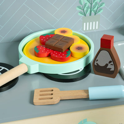 The TP Toys Owl & Fox Wooden Pancake Set - FSC® certified includes a toy frying pan, spatula, syrup bottle, strawberries, chocolate pieces, fruit slices, and a stovetop—ideal for imaginative pretend play.