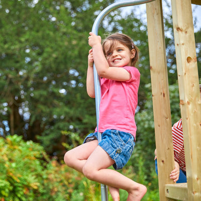 A young girl enjoys an outdoor adventure sliding down the 1.8m wavy slide on the TP Toys Castlewood climbing frame with Double Wooden Swing Arm—FSC® certified fun for active play.