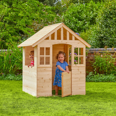 Two children enjoy imaginative play inside the Dandelion Cottage Wooden Playhouse by TP Toys, beautifully crafted from FSC® certified wood.