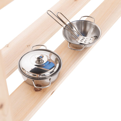 Two small metal kitchen pots from the TP Toys Little Chef Wooden Mud Kitchen - FSC® certified sit on a shelf; one has a lid, the other holds a slotted spatula and tongs—perfect for outdoor mud kitchen play.