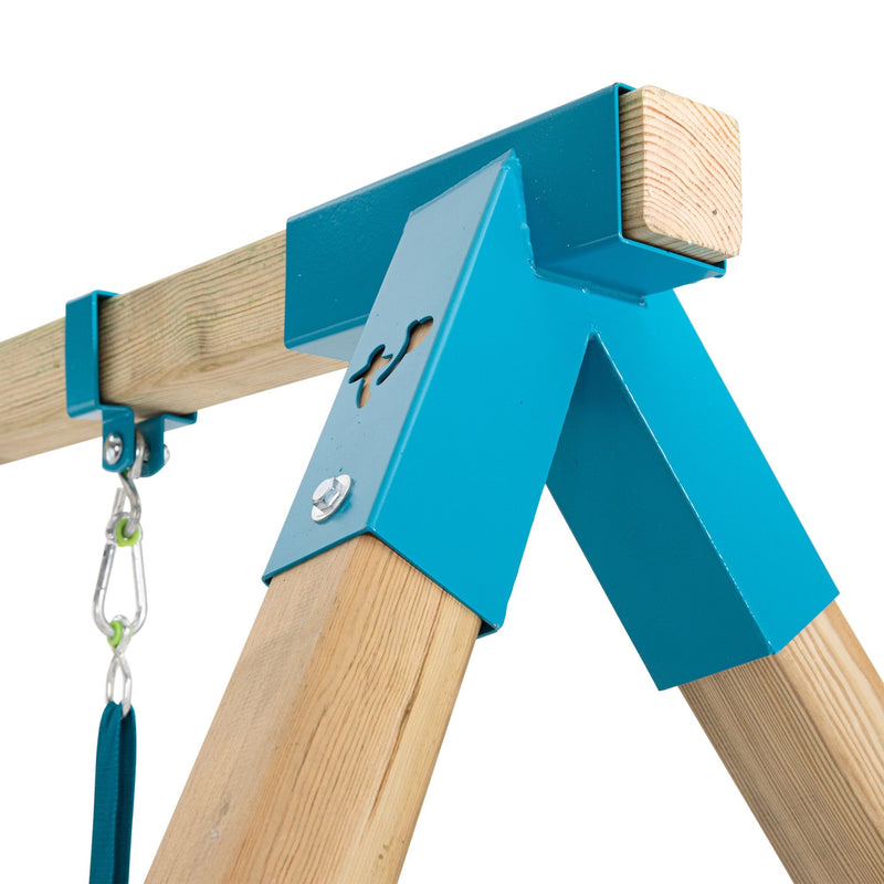 Close-up of the TP Toys Skywood Wooden Tower Climbing Frame, showing blue metal brackets on the swing arm, a swing hook, and part of the FSC®-certified structure with Ripple Slide, Monkey Bars & Double Swing Arm in the background.