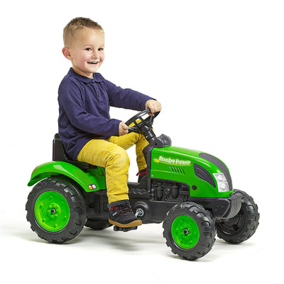 A young child smiles while riding the TP Toys Falk Country Farmer Pedal Tractor with Trailer, featuring a customizable number plate, against a white background.
