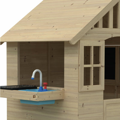 The Dandelion Cottage Playhouse by TP Toys is FSC® certified and features a mud kitchen with a plastic sink and faucet under the window, plus a table, bench, and shutters—perfect for imaginative outdoor play.