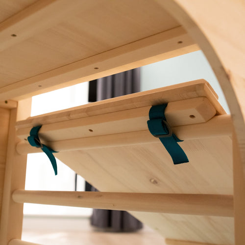 Close-up of the TP Toys TP Active-Tots Pikler Style Wooden Climbing Bridge and Slide – FSC® certified, featuring a ramp with two teal straps and buckles, ideal for any indoor play area or Montessori toy collection.