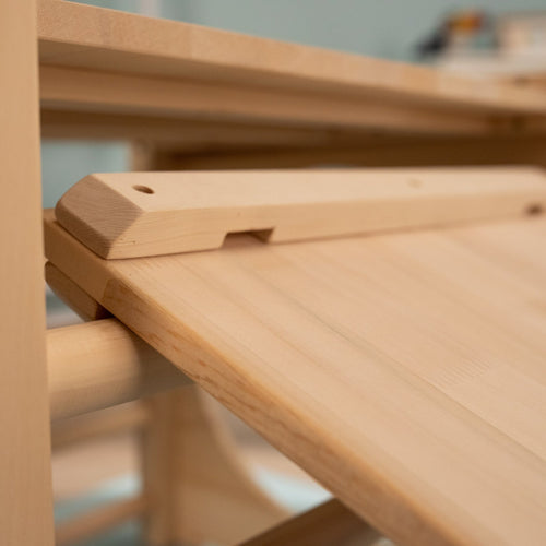 Close-up of the TP Toys TP Active-Tots Pikler Style Wooden Climbing Bridge and Slide, made from FSC® certified light wood, highlights its smooth unfinished surfaces and simple adjustable mechanism.