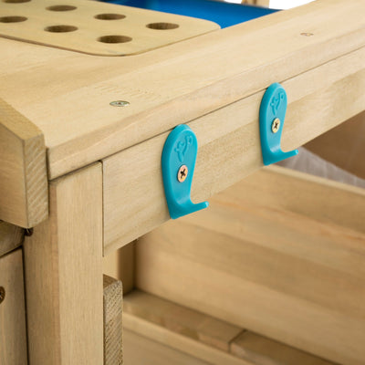 Close-up of the TP Toys TP Wooden Deluxe Potting Bench - FSC® certified, featuring two blue plastic hooks secured by screws—ideal for organizing gardening play accessories at a childrens garden station.