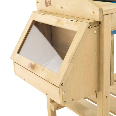 A close-up of the TP Toys TP Wooden Deluxe Potting Bench - FSC® certified, featuring a wooden storage compartment with a transparent slanted lid and round knob, perfect for organizing childrens gardening play accessories.