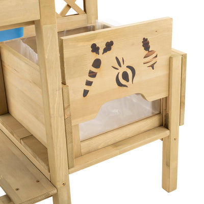 The TP Toys TP Wooden Deluxe Potting Bench - FSC® certified, features a pull-out drawer with vegetable cut-out designs and a plastic liner—ideal as a childrens garden station or for storing play gardening accessories.