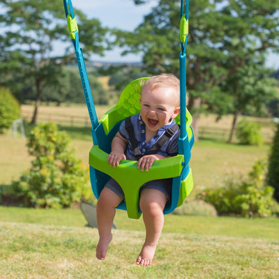 A baby enjoys gentle motion in the TP Toys Quadpod, securely attached to the TP Kingswood Double Squarewood Swing Set—an FSC® certified product.